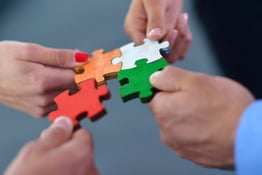 Business people assemble puzzle for team support